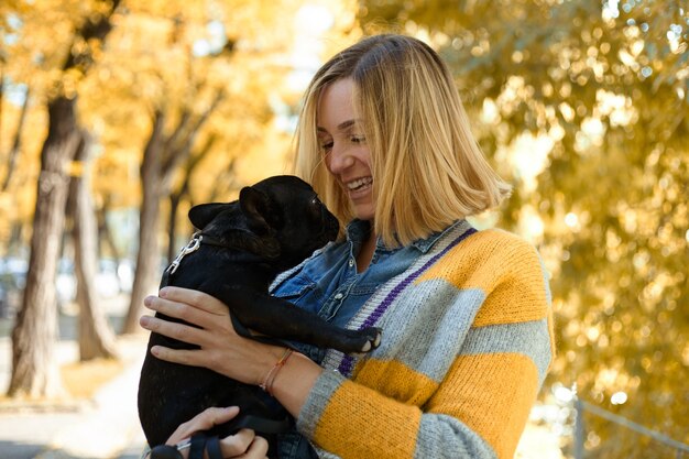 Close-up op gelukkige jonge vrouw met hond buiten in de herfst