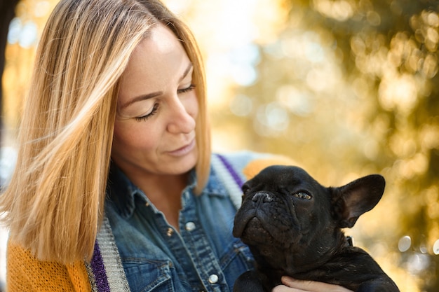 Close-up op gelukkige jonge vrouw met hond buiten in de herfst