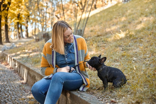 Close-up op gelukkige jonge vrouw met hond buiten in de herfst