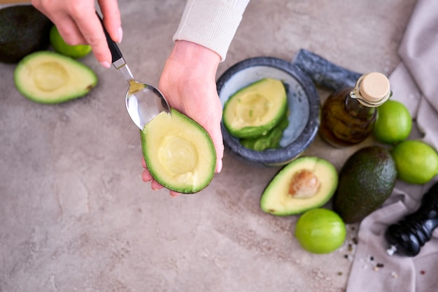 Close-up op handen met verse avocado die in tweeën is gesneden om guacamole te maken