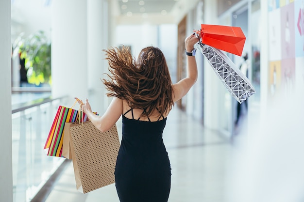 Close-up op jonge vrouw met boodschappentassen van Black Friday