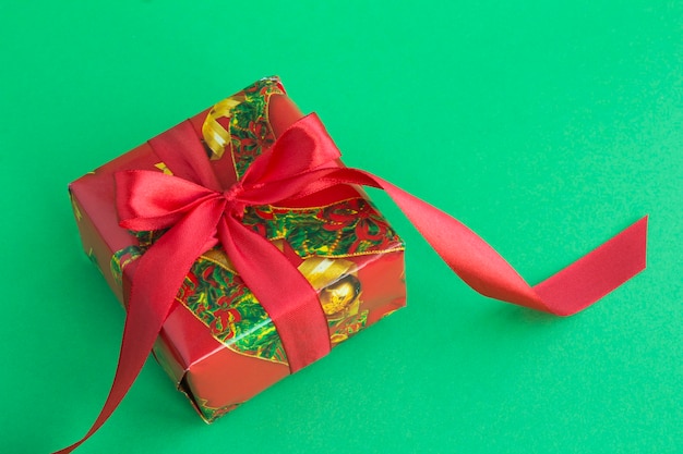 Close-up op kerstcadeau met rood lint op de groene achtergrond