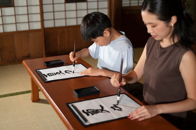 Close-up op leerlingen die Japanse kalligrafie doen, genaamd shodo