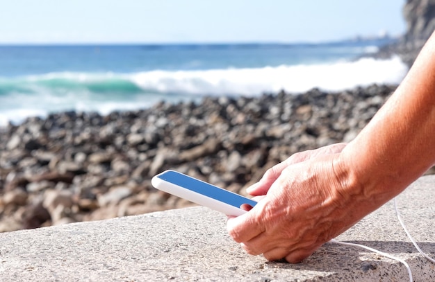 Close-up op menselijke vrouwelijke handen met een slimme telefoon met witte omslag Verslaving vrouw