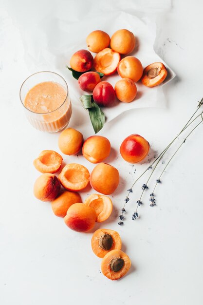 Close-up op rijpe abrikozen en abrikozen smoothie op witte achtergrond