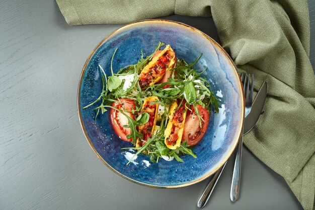 Close-up op smakelijk Italiaanse caprese salade met verse tomaten, zachte mozzarella, rucola en saus in blauwe kom