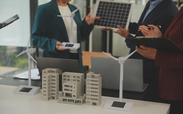 Close-up op tablet Ingenieurs wijzen met hun handen op tablet Om gezamenlijk het gebruik van hernieuwbare energie met wind- en zonne-energie te ontwerpen