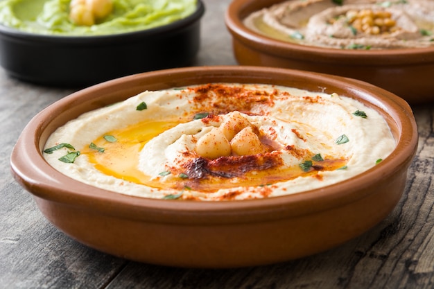 Close-up op verschillende hummus in kommen met kikkererwten en linzen