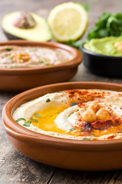 Close-up op verschillende hummus in kommen met kikkererwten en linzen