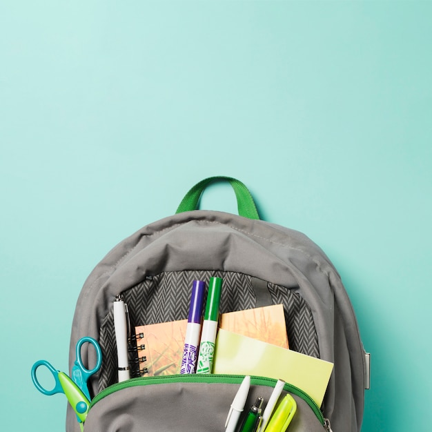 Photo close up opened backpack with school accessories