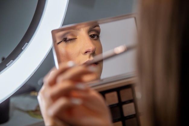 Close-up opname van een jonge blanke vrouw die make-up doet