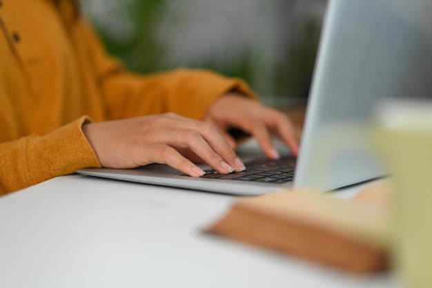 Close-up opname van een onherkenbare vrouw die op het toetsenbord schrijft, informatie zoekt of op het internet surft