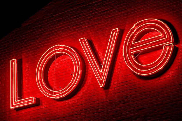 Close-up opname van een rood neon bord LOVE op de bakstenen muur's nachts het concept van liefde en romantiek