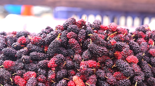 Close-up opname van een stapel rode moerbeien op een markt