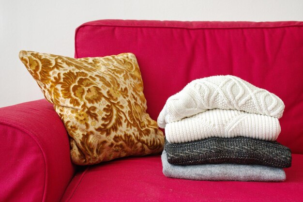 Foto close-up opname van warme truien en kussen op rode bank in de woonkamer