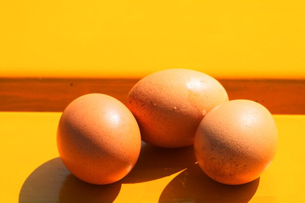 Photo close-up of orange eggs on table