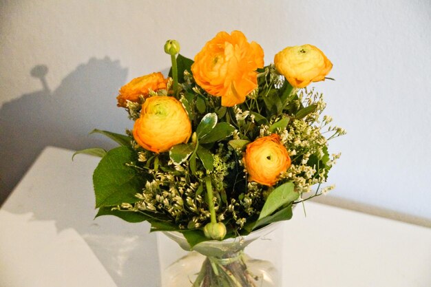 Photo close-up of orange flowers on table