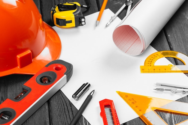 Close up orange hardhat and variety of repair tools 