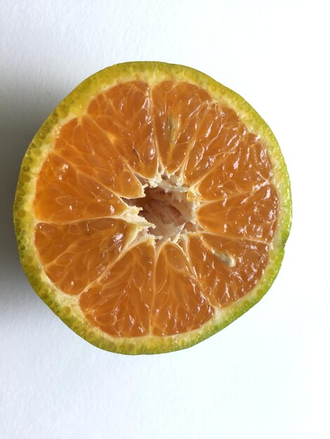 Photo close-up of orange slice against white background