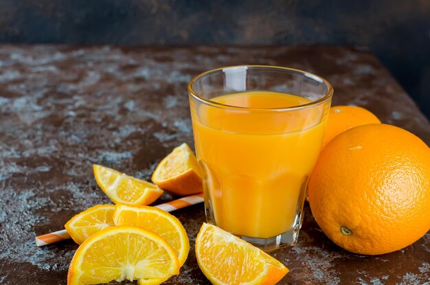 Close-up of orange slices and juice on weathered table