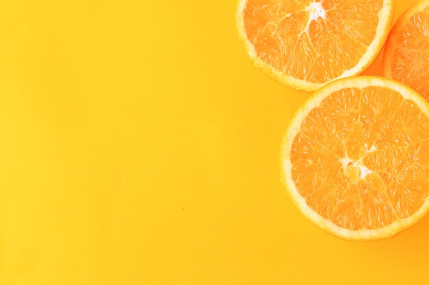 Close up of orange slices on yellow background