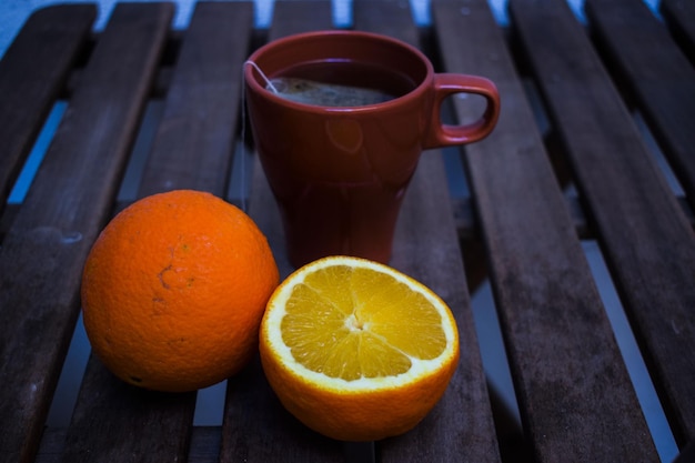 Foto close-up di arance vicino alla tazza di caffè sul tavolo