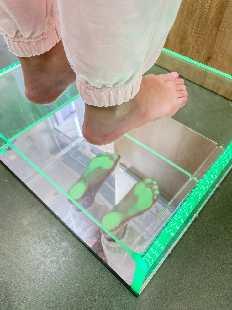 Photo close up of orthopedic doctor checks womans feet on plantoscope medical examination flatfoot