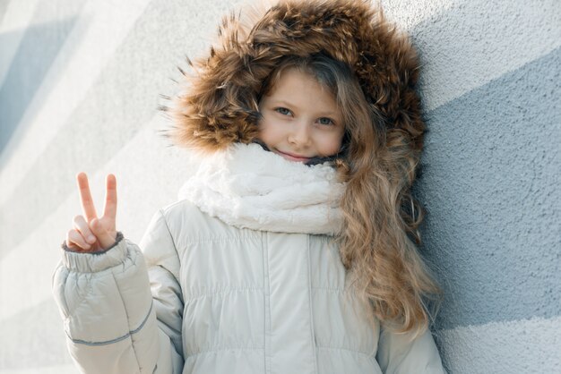 Photo close-up outdoor winter portrait of child blonde girl