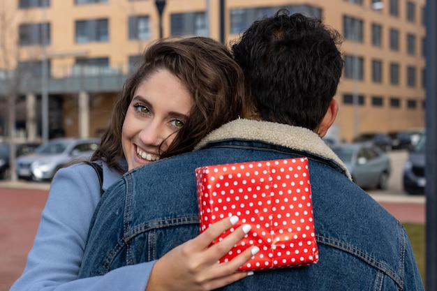 Close up overjoyed wife hugging husband, thanking for romantic present, surprise, happy attractive young woman holding gift box , couple celebrating anniversary, birthday or Valentines day