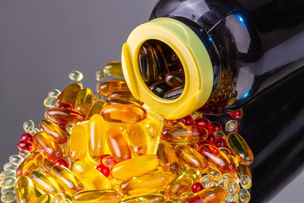 Close up overturned bottle with pile of vitamin pills omega vitamins capsules