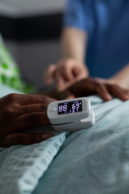 Close up of oximeter on african american girl hand