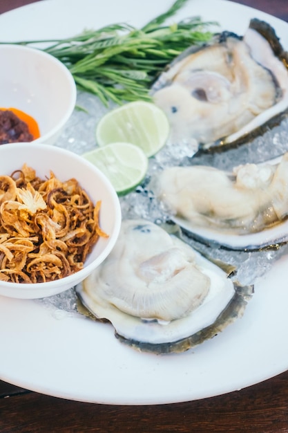 Photo close-up of oysters in plate on table