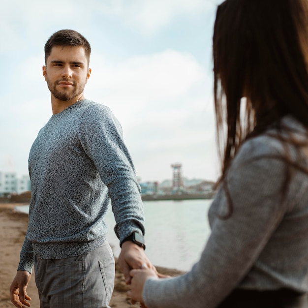 Foto close-up paar hand in hand op strand