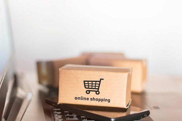 Close-up of packages with smart phone on laptop
