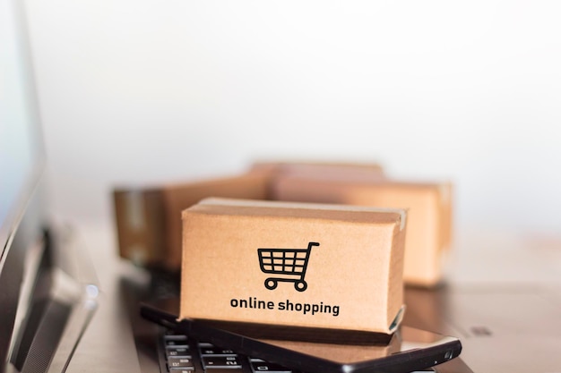 Close-up of packages with smart phone on laptop