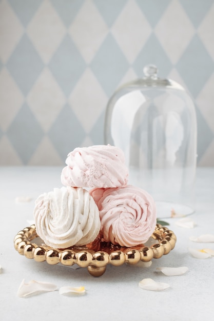 Chiuda sul zefiro d'imballaggio del dolce alla tavola. manichino con spazio per il concetto di cibo testo. torta su supporto e marshmallow con elementi di rose