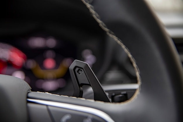 Close up paddle shifter sul volante in una moderna auto premium.speedshift cambio manuale stick sul volante di un'auto, dettagli interni auto