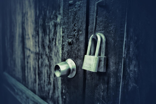 Photo close-up of padlock hanging on closed door