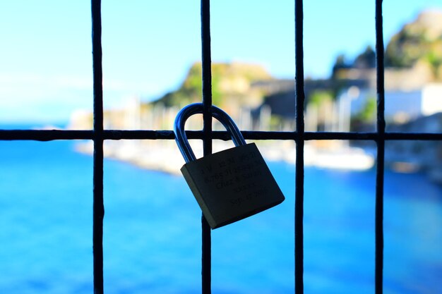 Photo close-up of padlocks hanging on metal against sky