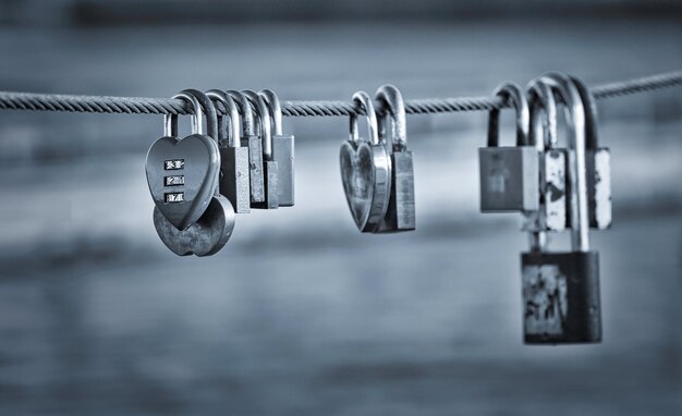 Photo close-up of padlocks hanging on railing