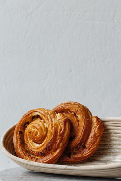 Close up of Pain aux raisins or Dutch koffiebroodje translation coffee roll on a white table