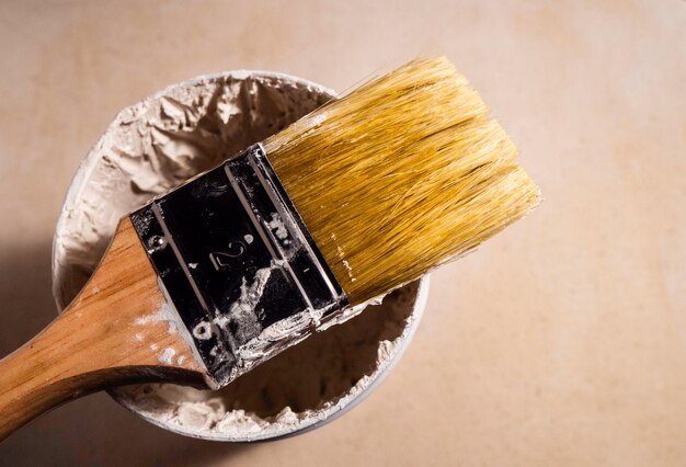 Close up of paint brush on textured wall