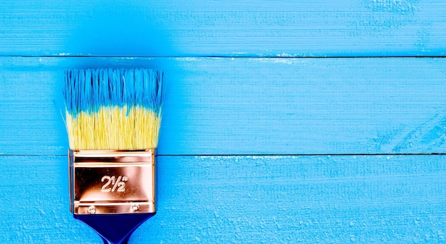 Close-up of paintbrush against blue table