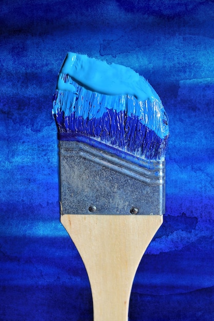 Close-up of paintbrush against blue wall