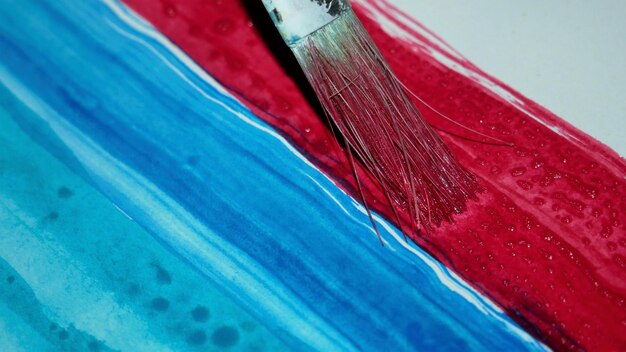 Close up of paintbrush on red color at table