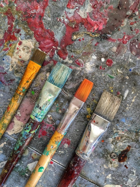 Close-up of paintbrushes arranged on old table