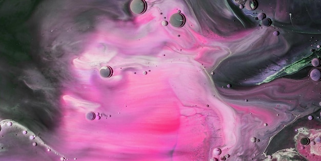 A close up of a painting of pink and purple paint with a black background.