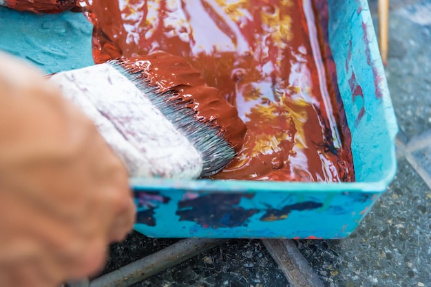 close up of paints and brushes, arista's hand painting a street mural