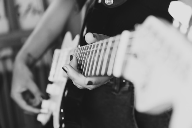 Close up of a pair of hands playing a guitar outdoors. sunny\
day and practicing an instrument concept. copy space music life on\
tour and nature.