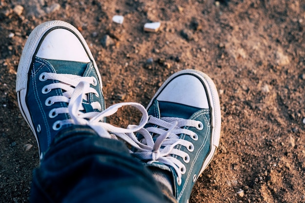 Close up of pair of sneakers blue shoes and jeans